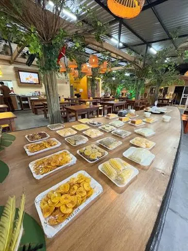Mesa do Naíza com banana frita, milho, bolos e outros itens do café regional